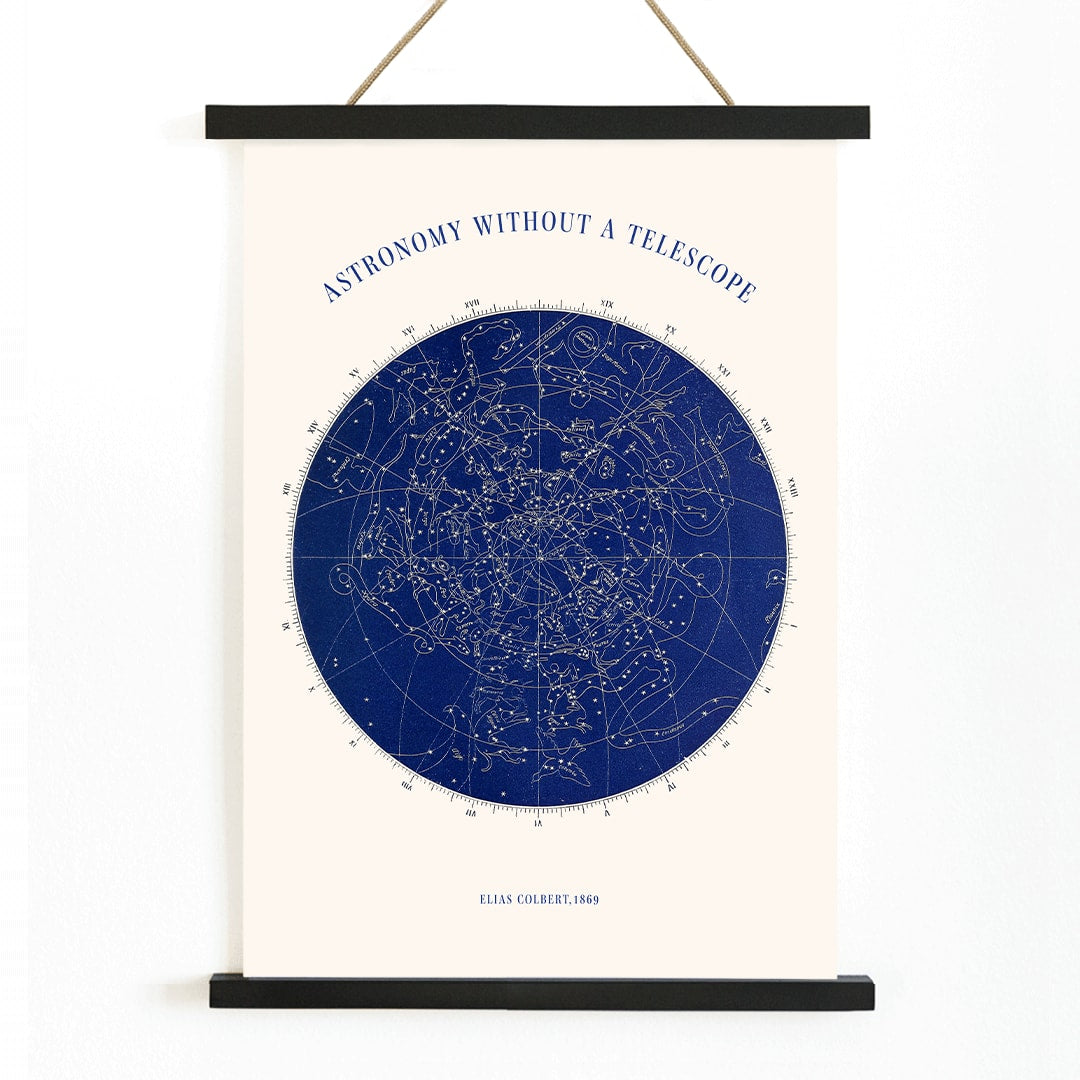 Star map and poster of constellations titled Astronomy without a Telescope by Elias Colbert featuring celestial star chart in blue, with wooden magnetic frame on white background
