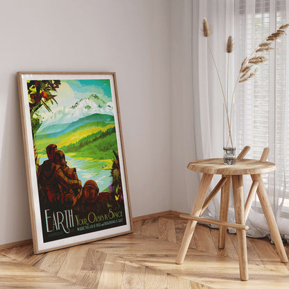 Two people in spacesuits admire a lush green landscape with mountains and a lake Earth Your Oasis in Space by NASA poster artwork, framed and displayed in home decor