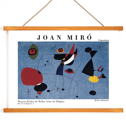 Exhibition poster of abstract artwork Woman and Bird at Night by Joan Miro with colorful shapes on a blue background, with wooden magnetic frame on white background