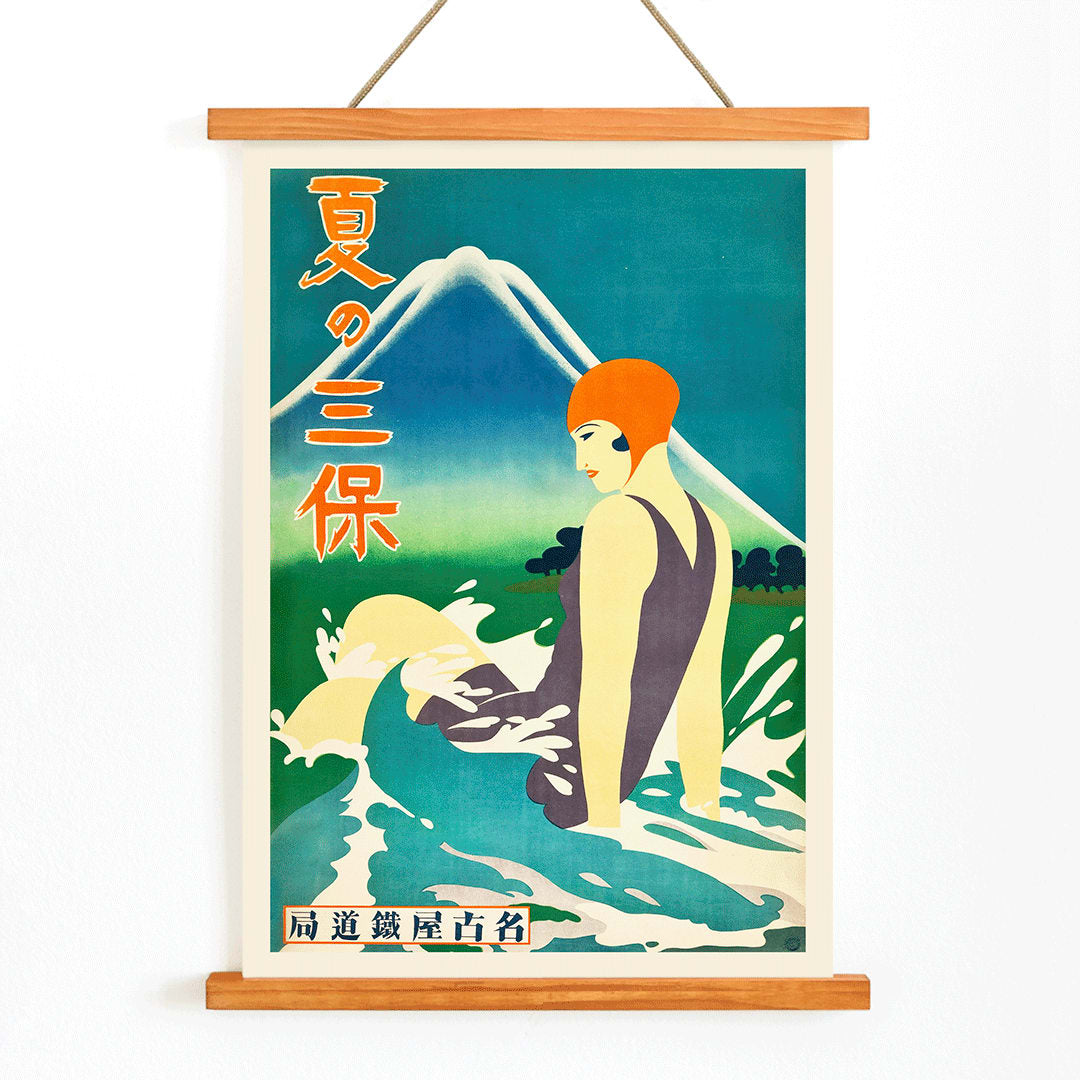 Japanese woman in bathing suit with orange cap sitting in waves at Miho Peninsula with Mount Fuji in background by Nagoya Rail Agency, with wooden magnetic frame on white background
