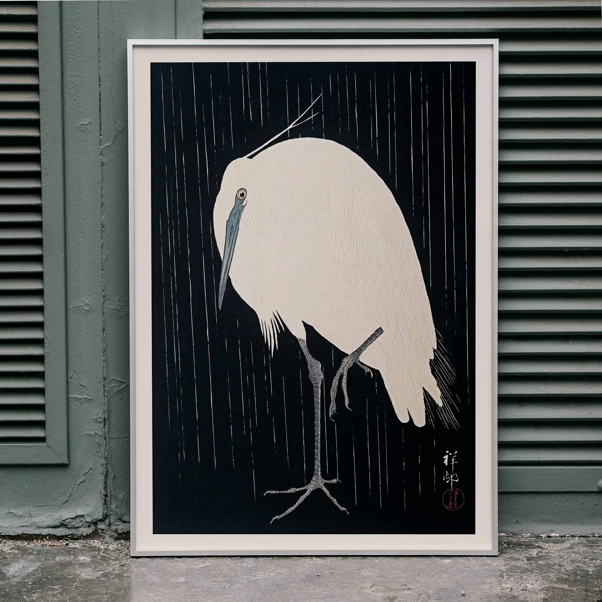 White egret standing in the rain art print poster with dark background by Ohara Koson, framed and displayed in home decor