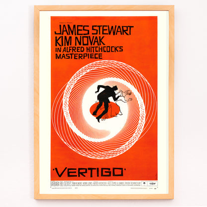 Closeup detail of Vertigo movie poster by Saul Bass featuring vibrant orange background swirling spiral and silhouetted figures graphic design